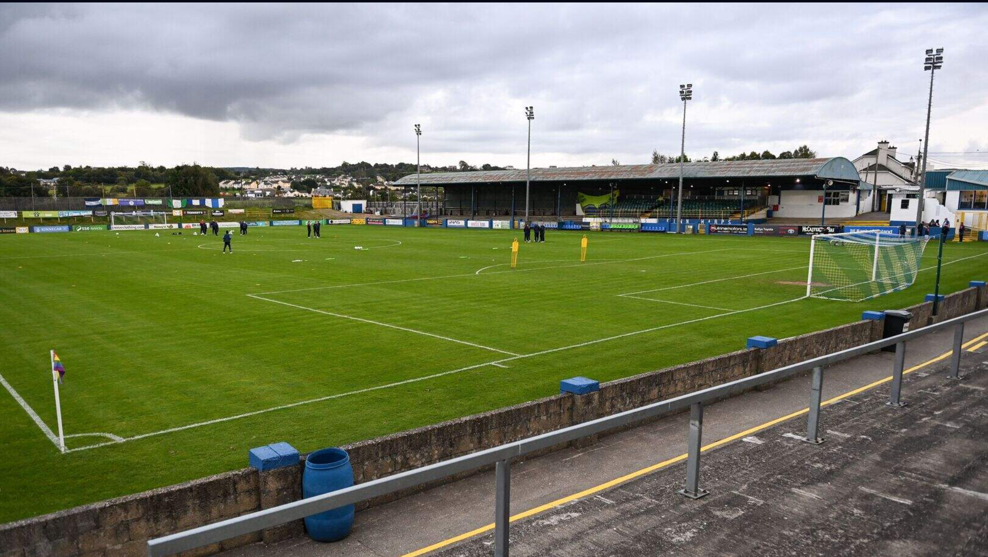 A tight provincial Irish ground with one covered stand and floodlights, an hour before kick-off